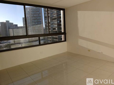 A spacious room with large windows overlooking a cityscape.