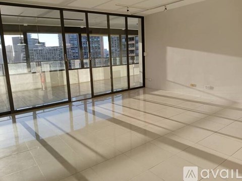 A spacious room with large windows and a tiled floor.