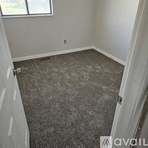 A room with a carpeted floor and a window.