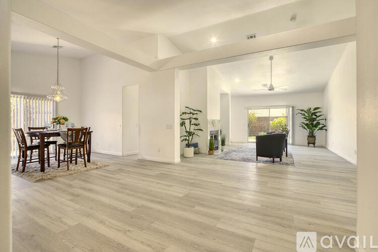 A spacious living room with a dining table and chairs.