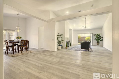 A spacious living room with a dining table and chairs.