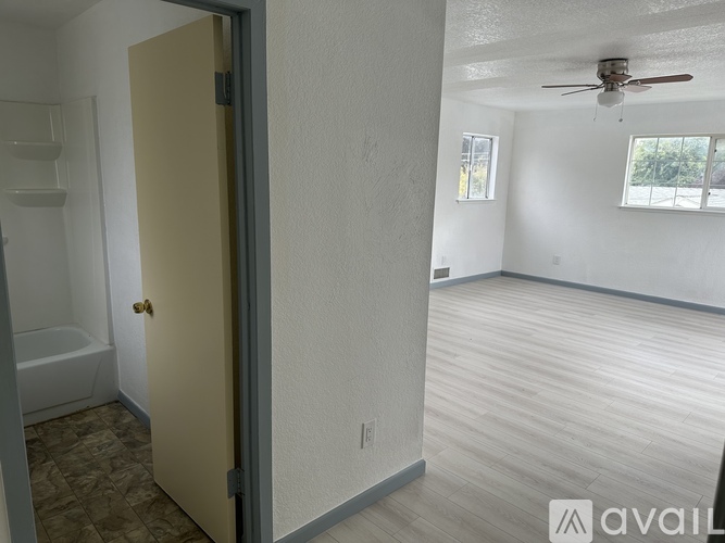 A room with a ceiling fan and a door leading to a bathroom.
