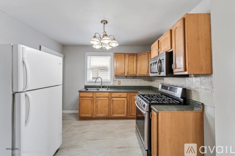 A kitchen with wooden cabinets and a white fridge.