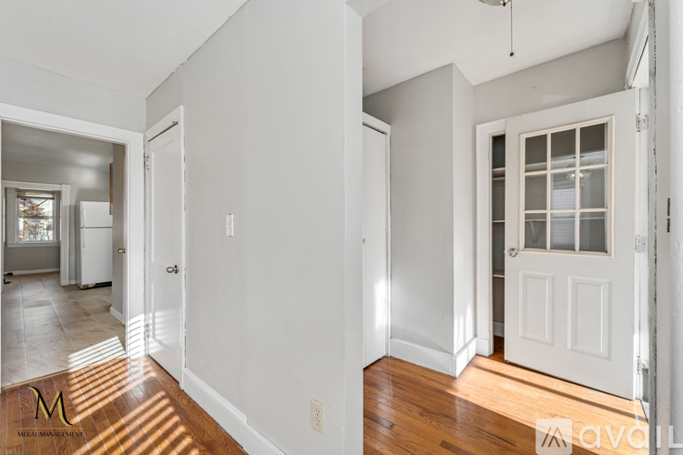 A white interior of a room with a door and a window.
