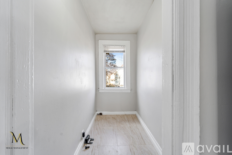 A long hallway with a window and a door on the left.