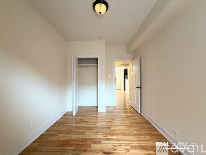 A long hallway with wooden floors and white walls.