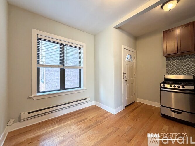 A kitchen with a stove and a window with blinds.