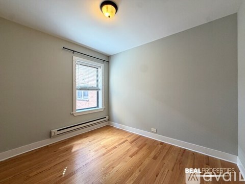 A room with a window and wooden flooring.