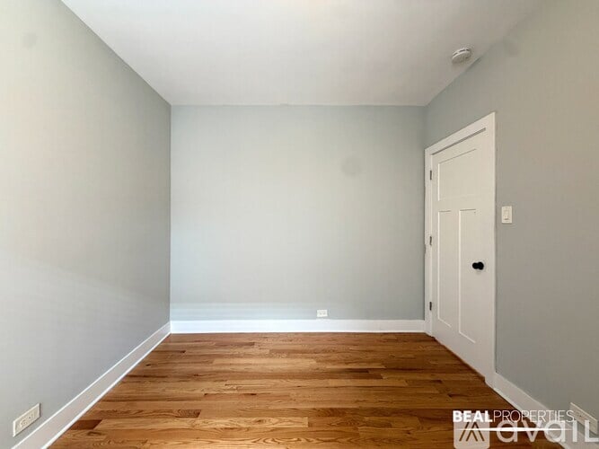 A room with a wooden floor and a white door.