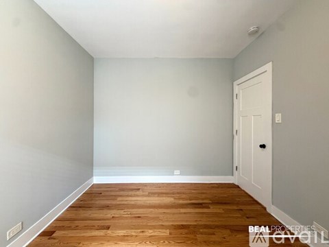 A room with a wooden floor and a white door.