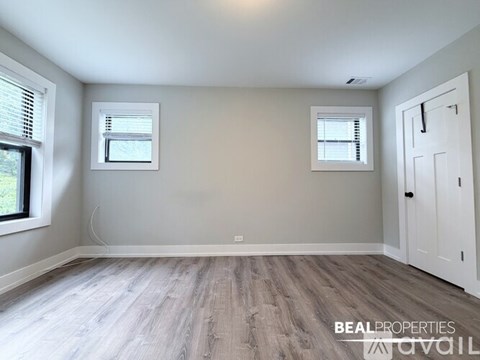 A room with wooden flooring and white walls.