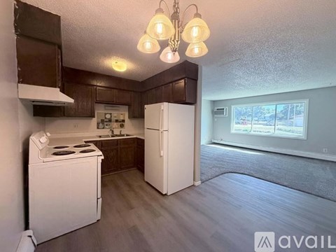 A kitchen with white appliances and brown cabinets.