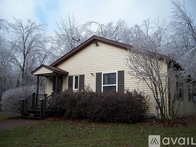 A house with a brown roof and a porch with a railing.