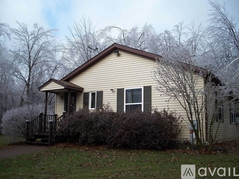 A house with a brown roof and a porch with a railing.