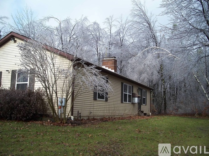 A house with a brown roof and a tree in front of it.