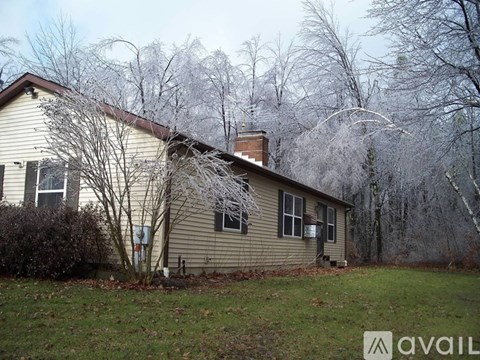 A house with a brown roof and a tree in front of it.