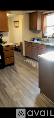 A kitchen with wooden cabinets and a white counter.