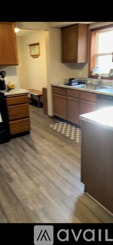 A kitchen with wooden cabinets and a white counter.