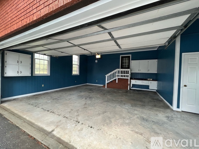 A spacious garage with a white ceiling and a brick wall.