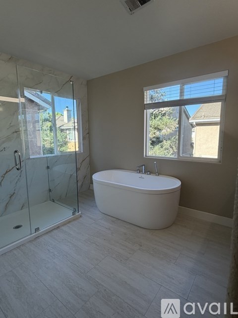 A bathroom with a white tub and a walk-in shower.