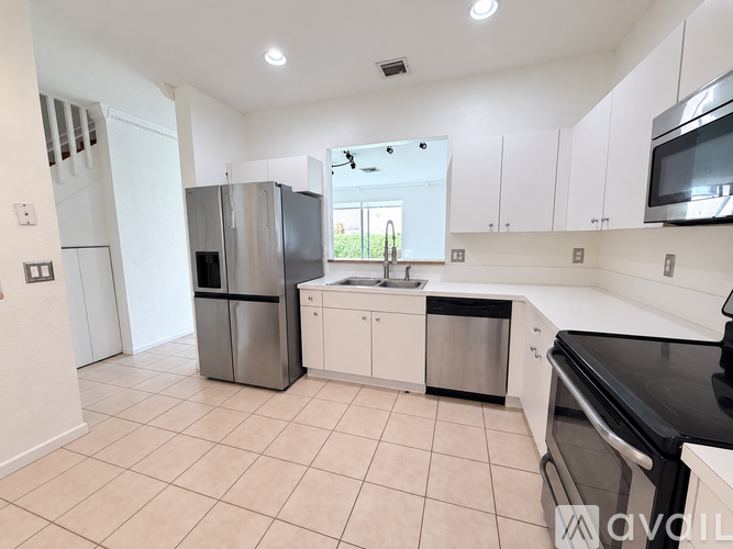 A kitchen with white cabinets and appliances.