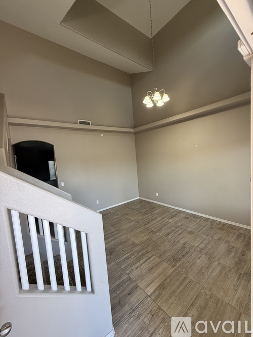 A room with wooden flooring and a white door with bars.