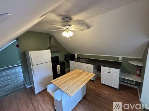 A kitchen with a wooden table and white cabinets.