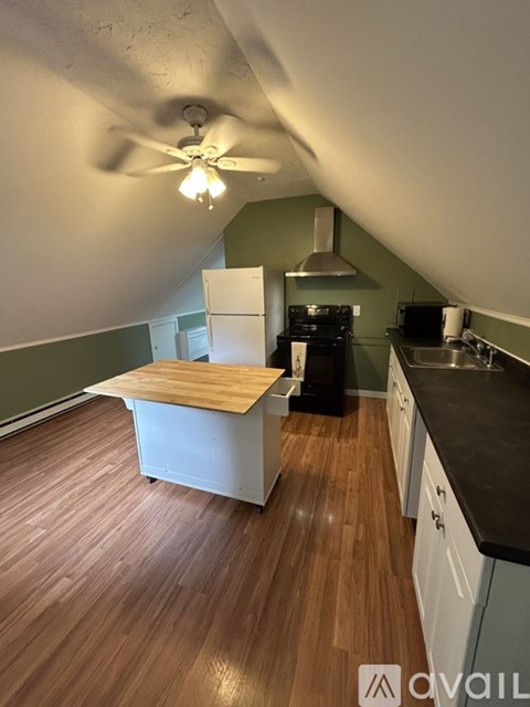 A kitchen with a wooden floor and white cabinets.