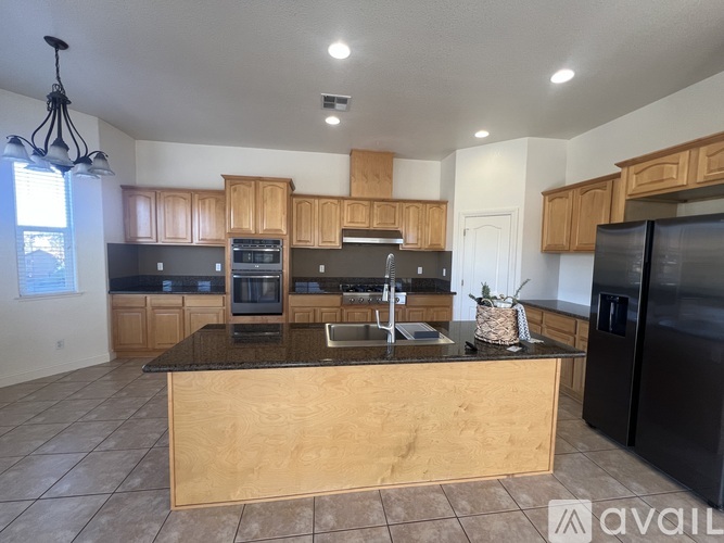 A kitchen with wooden cabinets and black appliances.