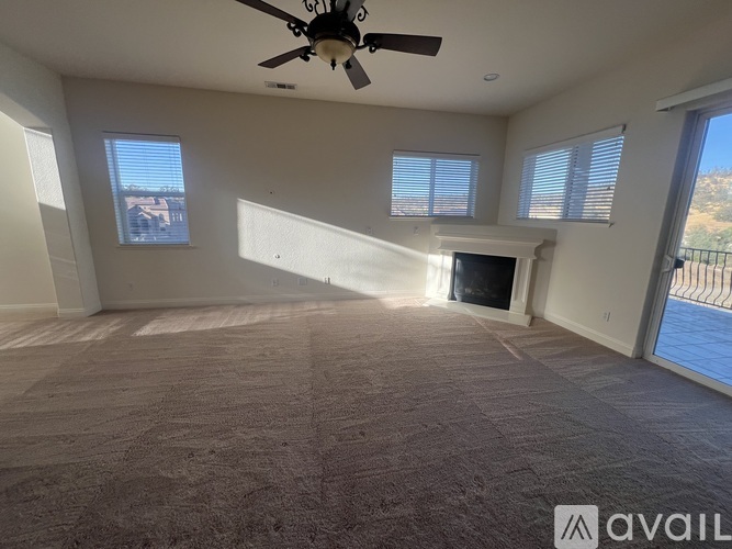 A spacious living room with a fireplace and large windows.