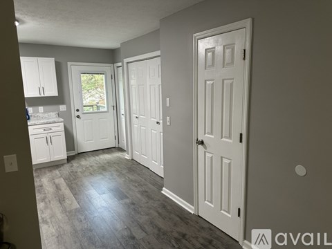 A kitchen area with a sink, cabinets, and a window.