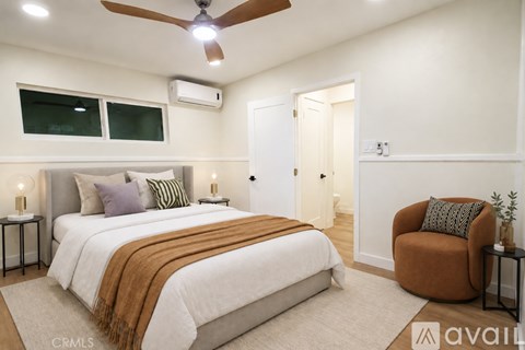 A bedroom with a large bed and a brown armchair.