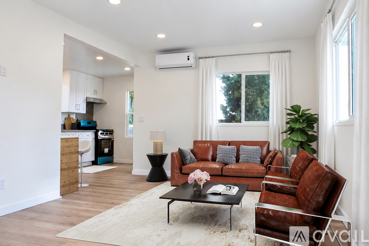 A living room with a brown leather couch and a black coffee table.