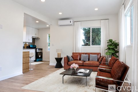 A living room with a brown leather couch and a black coffee table.