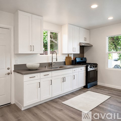 A kitchen with white cabinets and a dark countertop.