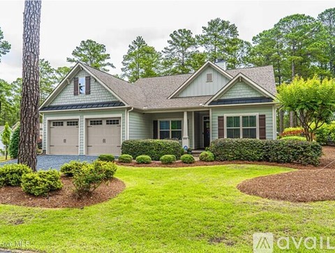 A house with a grey roof and a green lawn in front.