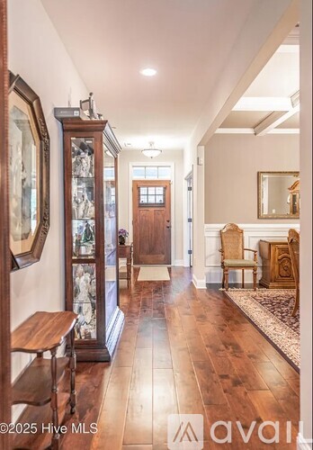 A hallway with wood floors and a bench.