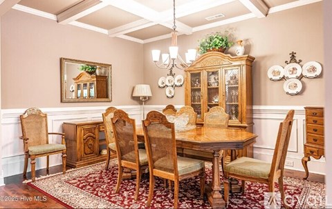 A dining room with a wooden table and chairs.
