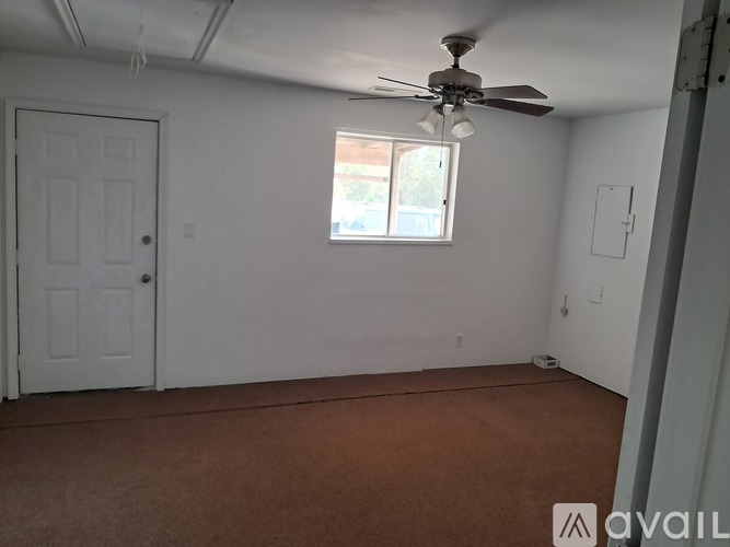 A room with a ceiling fan and a window.