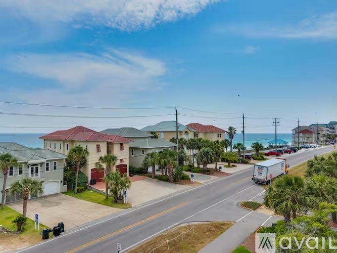 A street view of a residential area with houses and a truck driving by.