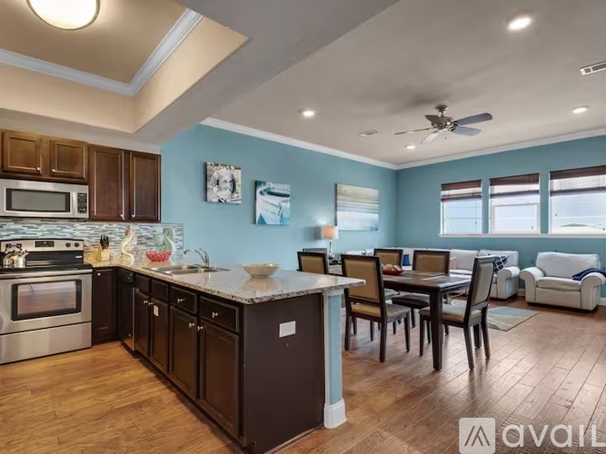A kitchen with dark wood cabinets and a blue wall.