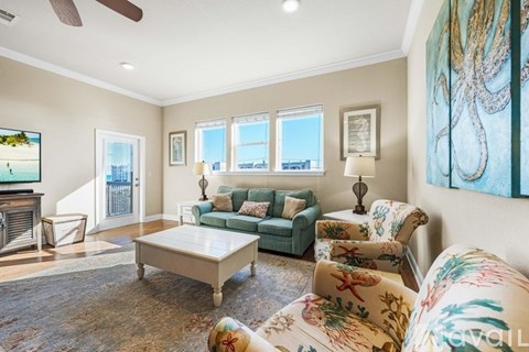 A living room with a couch, chairs, and a television.