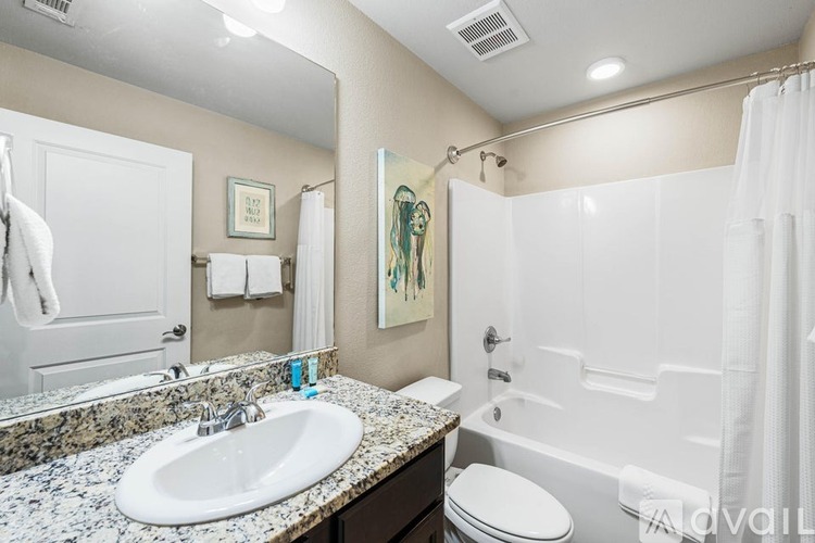 A bathroom with a white sink, toilet, and bathtub.