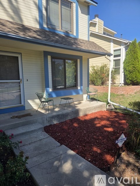 A house with a red mulch garden bed in front of it.