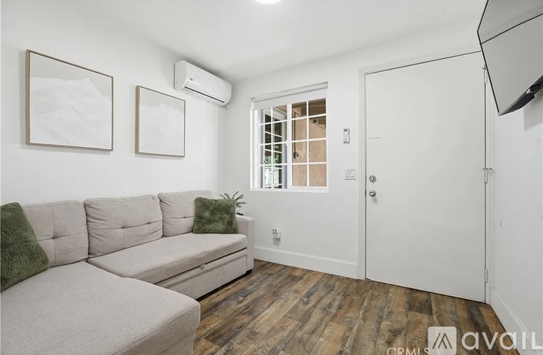 A living room with a grey couch and a white door.