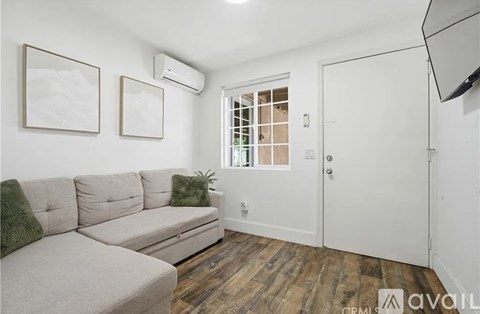 A living room with a grey couch and a white door.