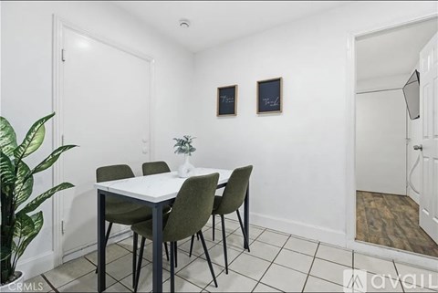 A dining room with a white table and green chairs.