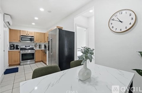 A kitchen with a white table and a clock on the wall.