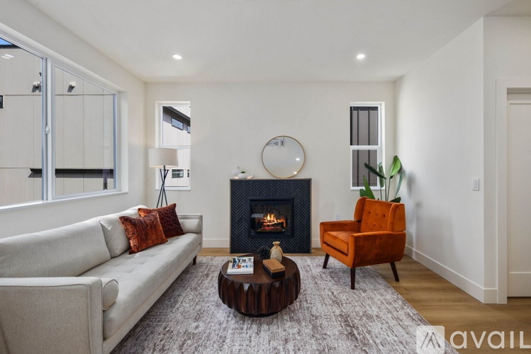 A modern living room with a fireplace and a grey sofa.