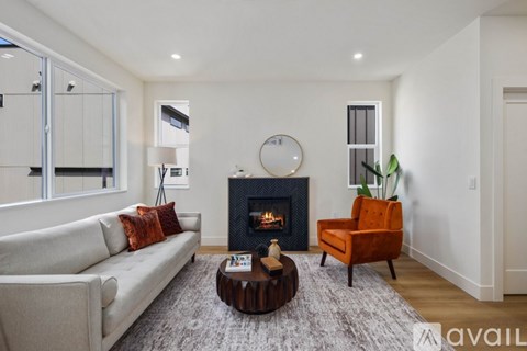 A modern living room with a fireplace and a grey sofa.